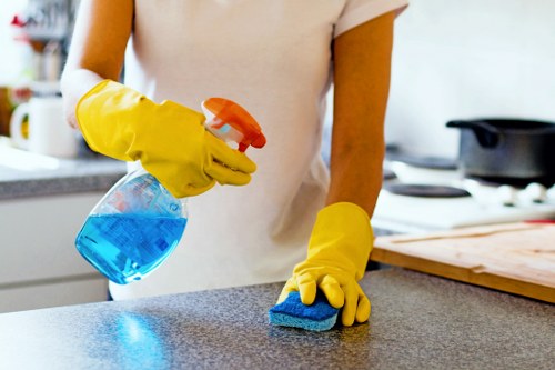 Office cleaning service dusting workstations and desks
